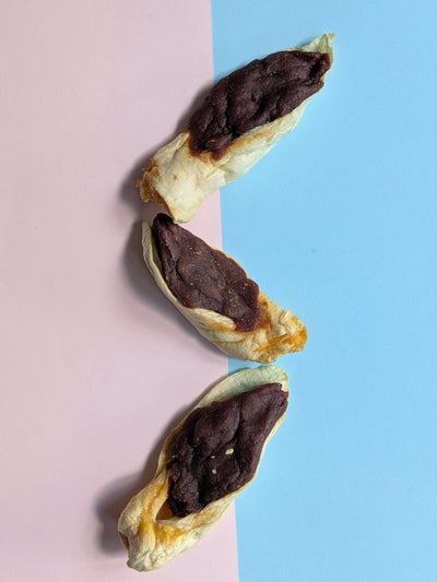 Beef filled rabbit ears natural dog treat on colourful background